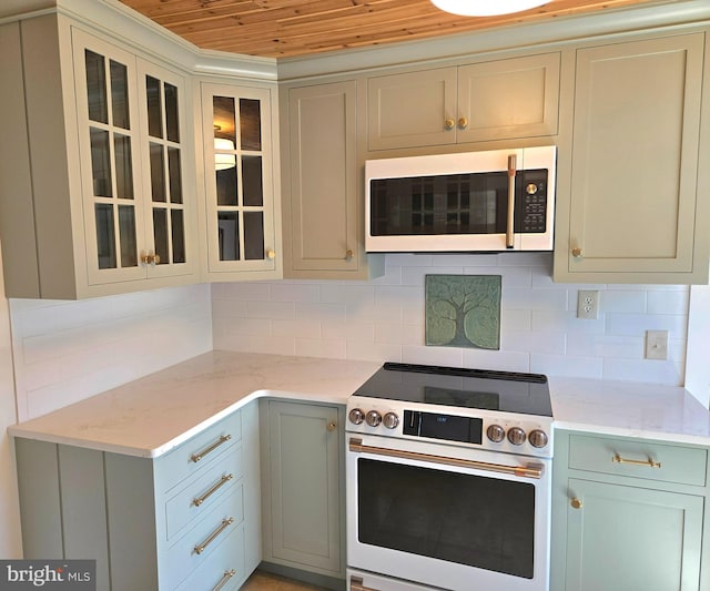 kitchen featuring tasteful backsplash, white microwave, light stone counters, wood ceiling, and range with electric cooktop