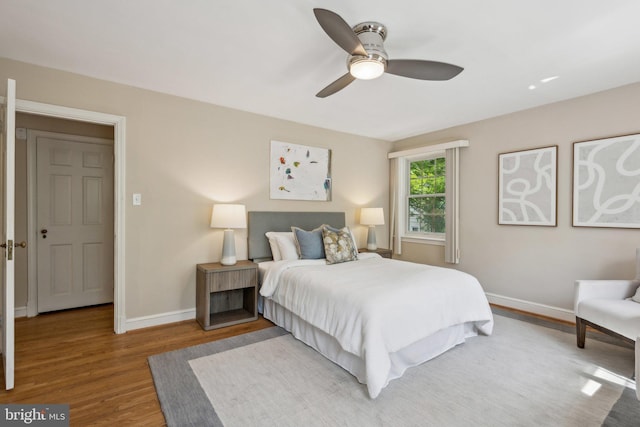 bedroom featuring baseboards, ceiling fan, and wood finished floors