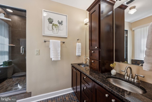 full bath featuring a sink, baseboards, a stall shower, and a wealth of natural light