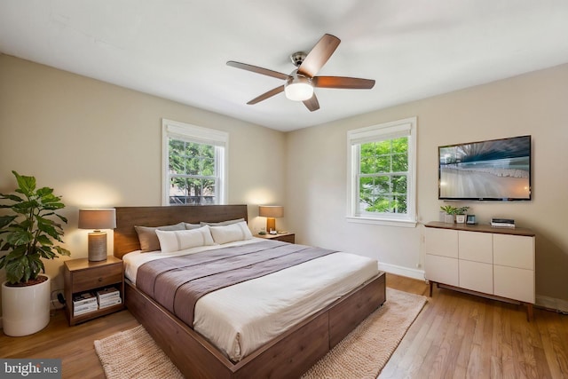 bedroom featuring light wood-type flooring, a ceiling fan, and baseboards