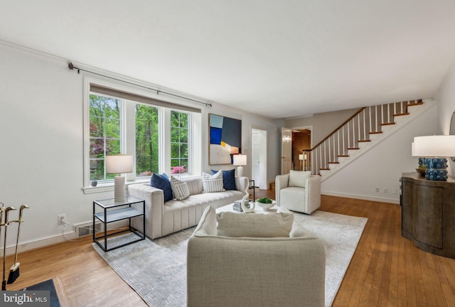 living area with stairs, baseboards, and wood finished floors