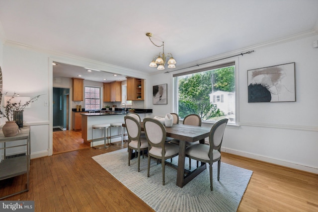 dining room with crown molding, wood finished floors, and a notable chandelier