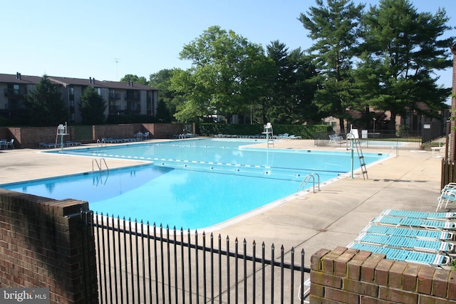 community pool featuring fence and a patio area