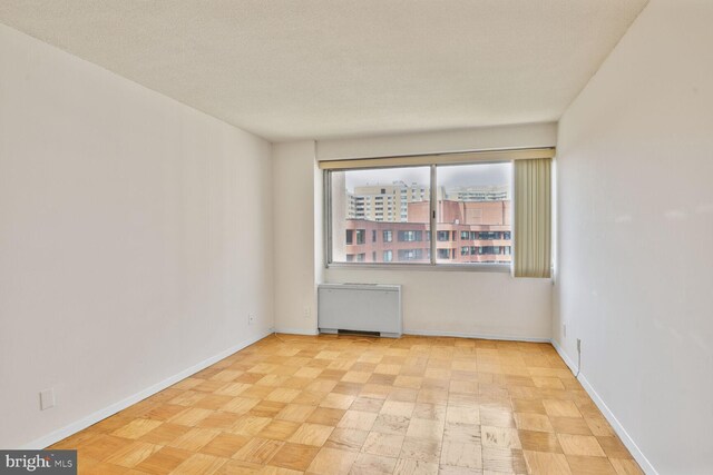 4515 Willard Ave Unit 1710S, Chevy Chase, MD 20815 - empty room featuring baseboards, radiator heating unit, and light floors