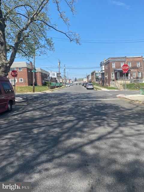 view of road with a residential view, traffic signs, and curbs