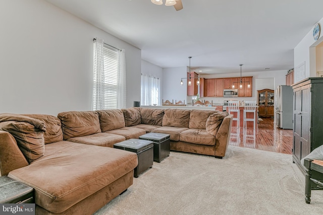 living area featuring ceiling fan and light carpet