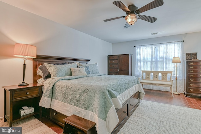 bedroom featuring visible vents, a ceiling fan, and wood finished floors