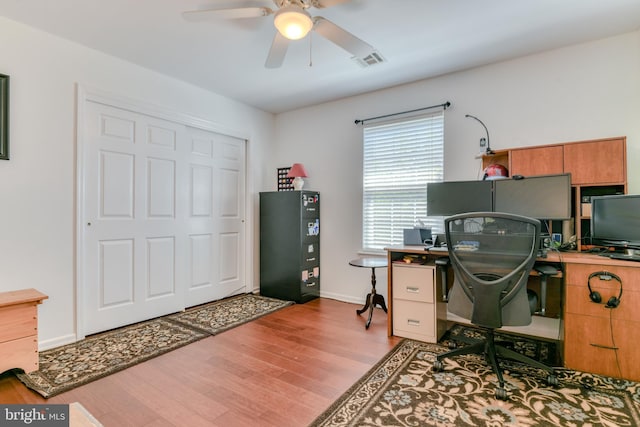 home office with baseboards, a ceiling fan, wood finished floors, and visible vents