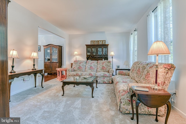 carpeted living room with baseboards