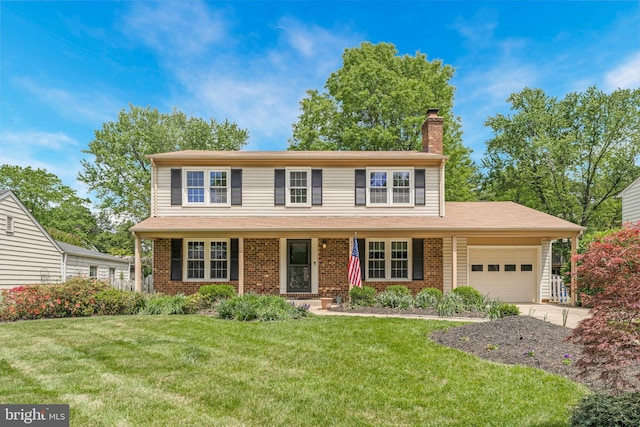 traditional-style house featuring brick siding, driveway, a garage, a front yard, and a chimney