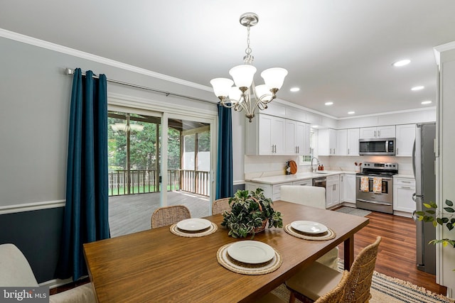 dining area with recessed lighting, a notable chandelier, dark wood finished floors, and crown molding