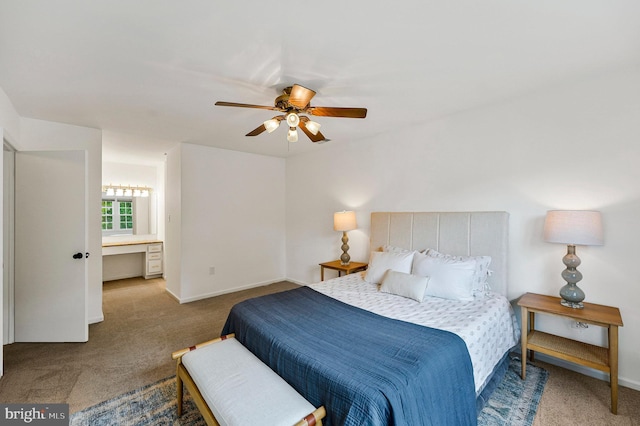 carpeted bedroom with baseboards, connected bathroom, and ceiling fan