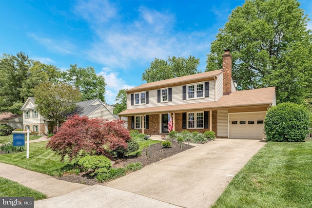 view of front of house with an attached garage, a chimney, a front lawn, a porch, and driveway