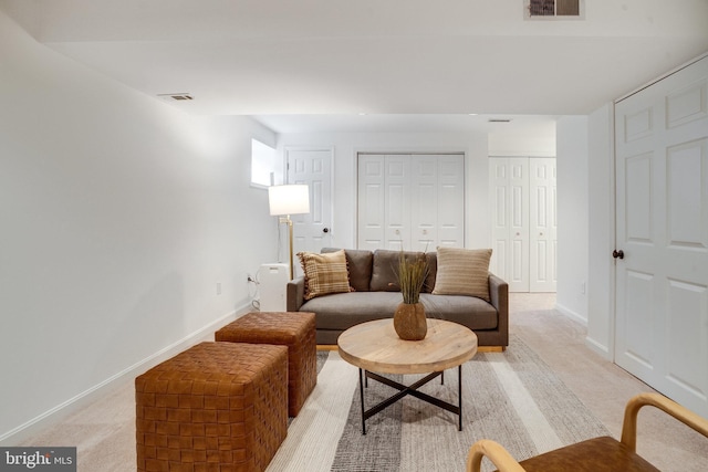 living room featuring baseboards, light carpet, and visible vents