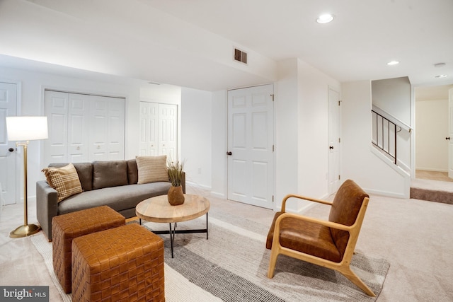 living area with stairway, light carpet, visible vents, and recessed lighting