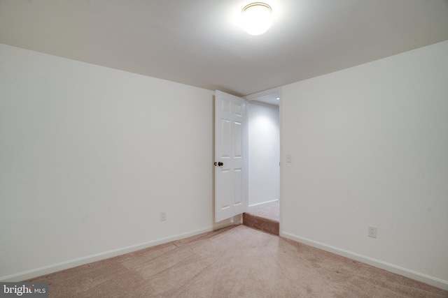 unfurnished room with light carpet and baseboards