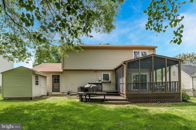 back of property featuring a yard, a sunroom, and a deck