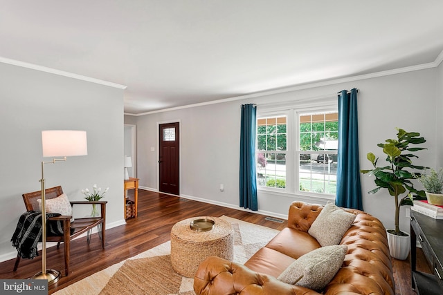 living room featuring baseboards, ornamental molding, visible vents, and wood finished floors