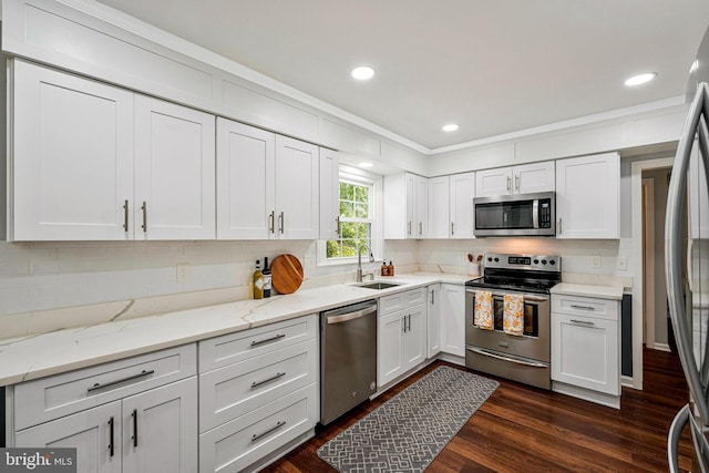 kitchen with white cabinetry, tasteful backsplash, appliances with stainless steel finishes, and a sink