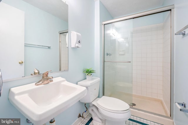 full bathroom featuring toilet, tile patterned floors, a shower stall, and a sink