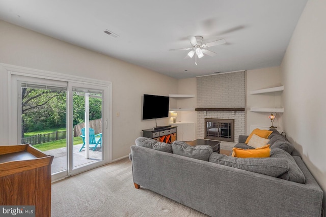 living room featuring a ceiling fan, light colored carpet, visible vents, and a fireplace