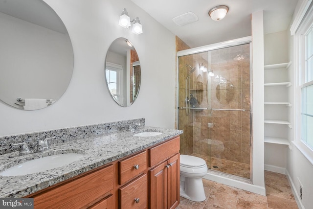 bathroom with a sink, a shower stall, and toilet