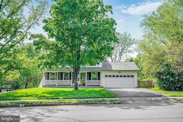 view of front of house featuring a garage, a front lawn, aphalt driveway, fence, and a porch