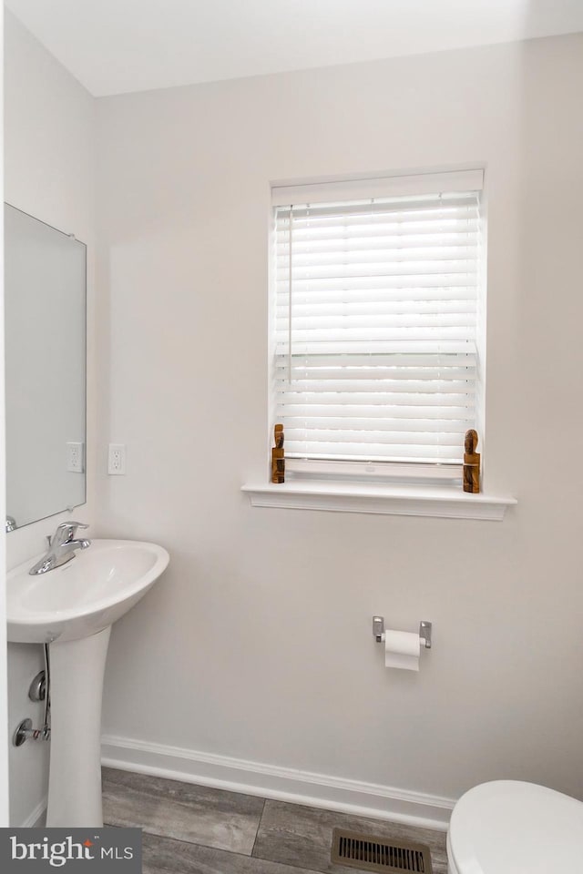 bathroom with baseboards, visible vents, and toilet