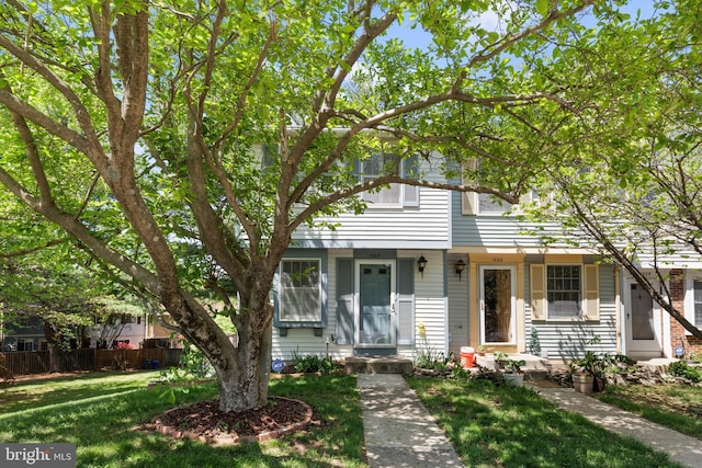 view of property with fence and a front lawn