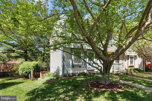 view of property hidden behind natural elements featuring a front yard