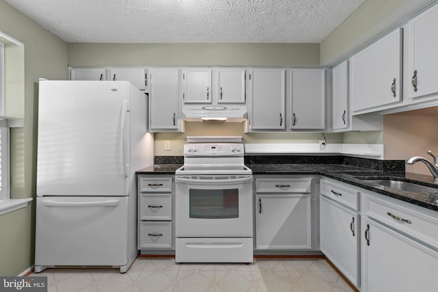 kitchen featuring dark stone countertops, white appliances, under cabinet range hood, a sink, and white cabinetry