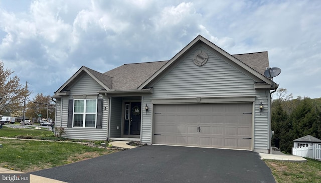 ranch-style home featuring a shingled roof, driveway, and an attached garage