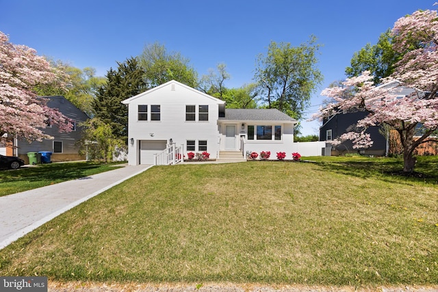 split level home with a garage, driveway, and a front yard