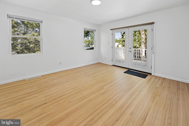foyer entrance with baseboards, french doors, wood finished floors, and visible vents