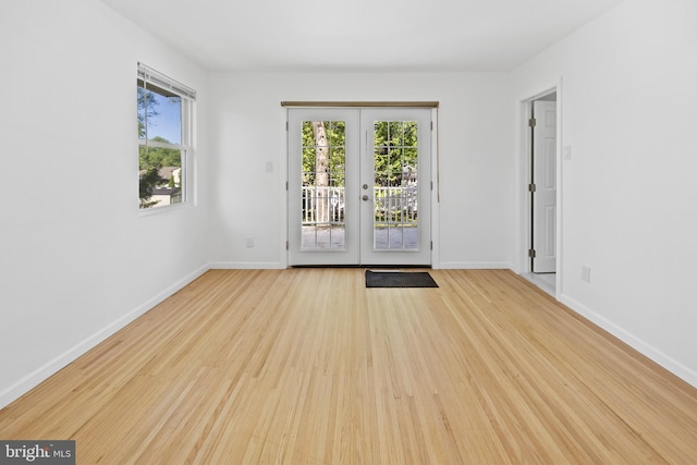 entryway featuring a healthy amount of sunlight, baseboards, french doors, and light wood-style flooring