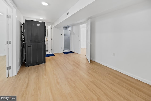 finished below grade area featuring baseboards and light wood-type flooring