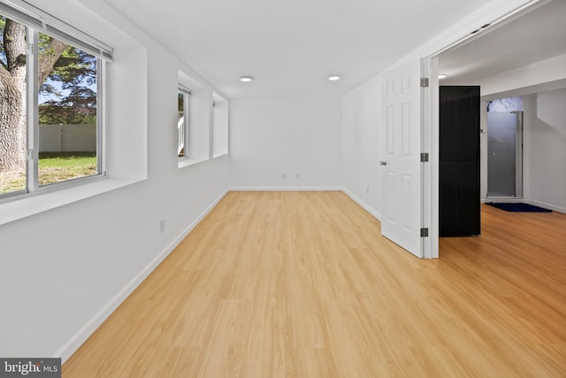 empty room with baseboards, recessed lighting, and light wood-style flooring