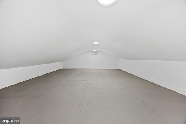 additional living space featuring baseboards and vaulted ceiling