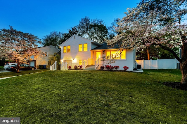 split level home with a front lawn and fence