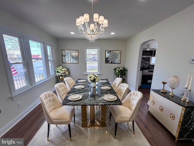 dining area featuring baseboards, arched walkways, a healthy amount of sunlight, and recessed lighting