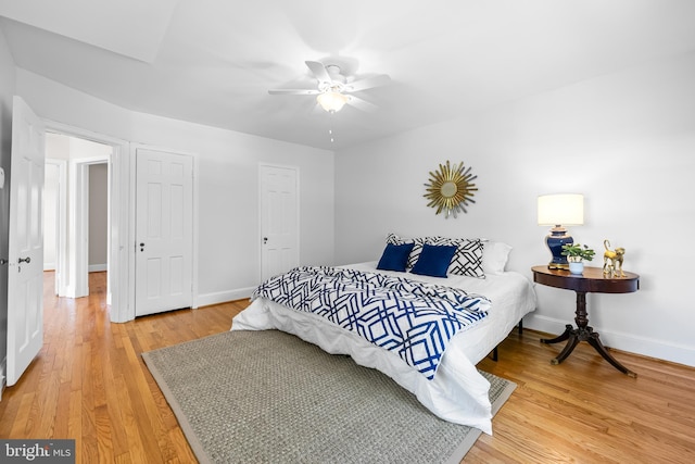 bedroom featuring a ceiling fan, baseboards, and light wood-type flooring