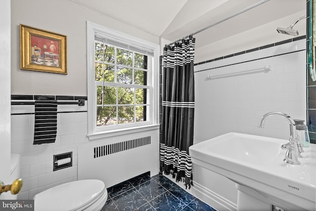 full bathroom with a sink, toilet, radiator heating unit, marble finish floor, and tile walls