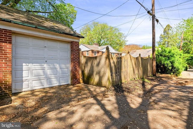 garage featuring fence and driveway