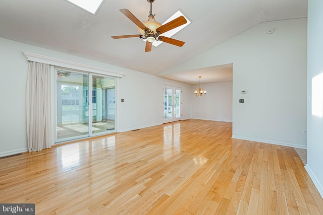 unfurnished room featuring a chandelier, a ceiling fan, light wood-type flooring, and high vaulted ceiling