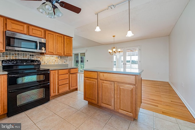 kitchen featuring stainless steel microwave, double oven range, light tile patterned floors, a ceiling fan, and tasteful backsplash