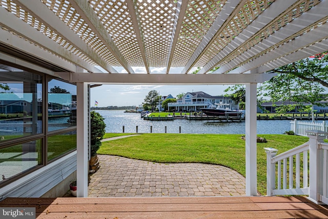 wooden deck with a water view, a lawn, a pergola, and a dock
