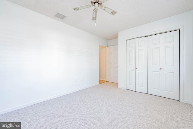 unfurnished bedroom featuring carpet flooring, baseboards, a closet, and ceiling fan