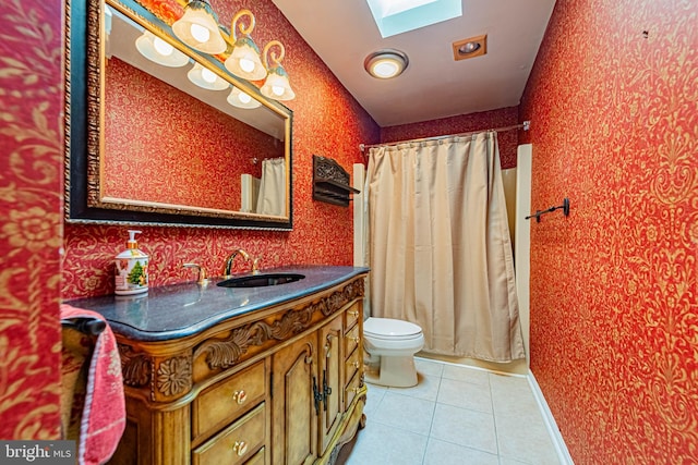 full bath featuring a skylight, toilet, tile patterned flooring, wallpapered walls, and vanity
