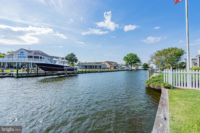 water view featuring fence and a dock