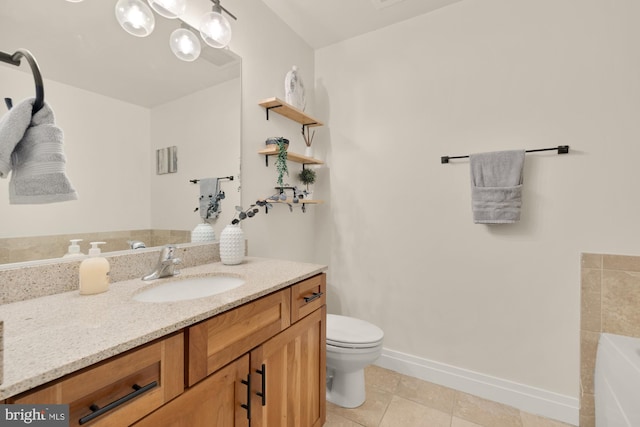 bathroom featuring a bathtub, vanity, tile patterned floors, baseboards, and toilet